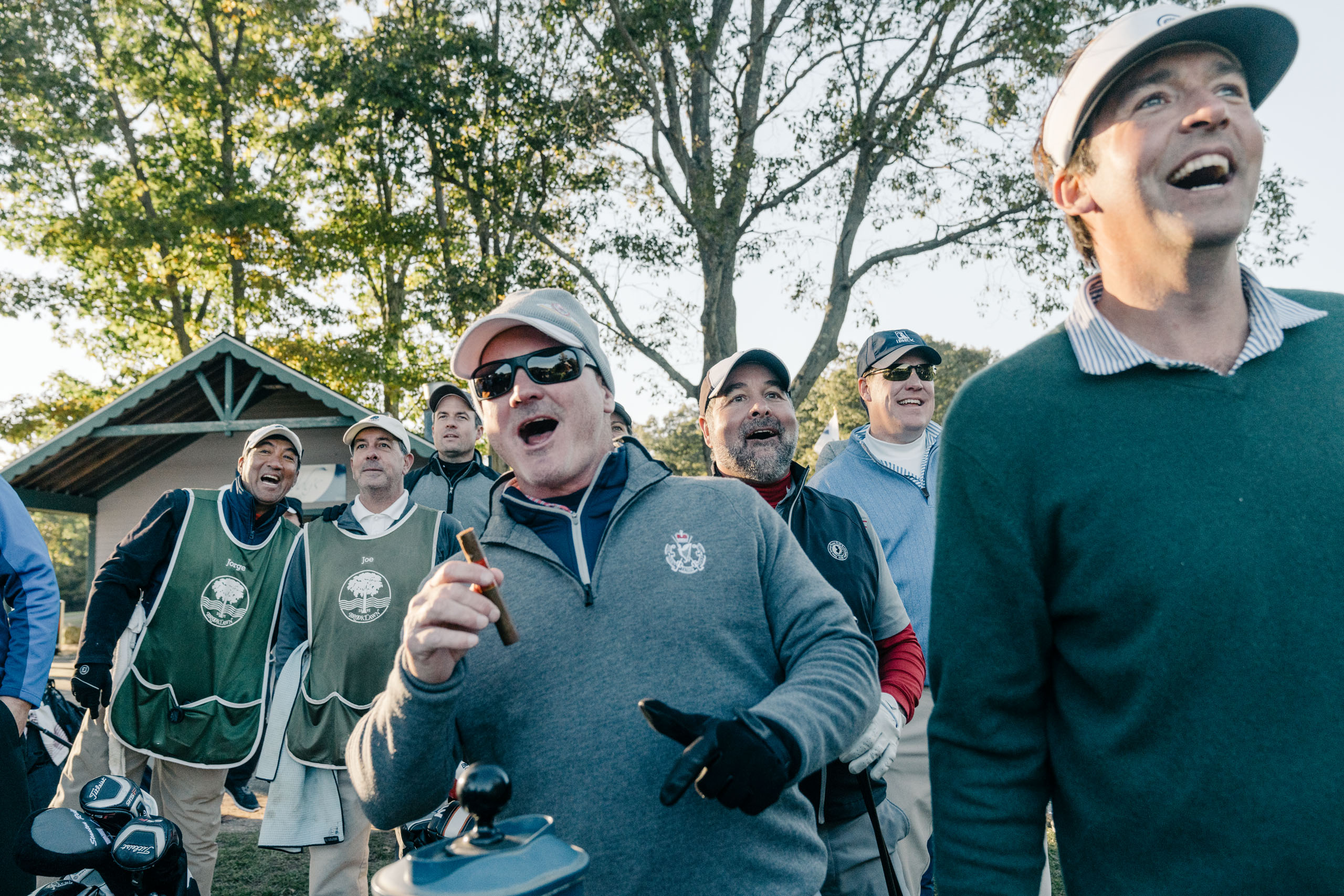 Members of the Outpost Club smoking cigars and watching golf.